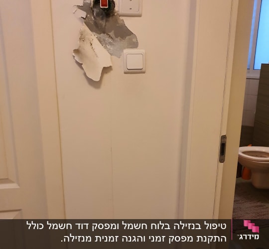 קיר עם חור ושני מתגים חשמליים